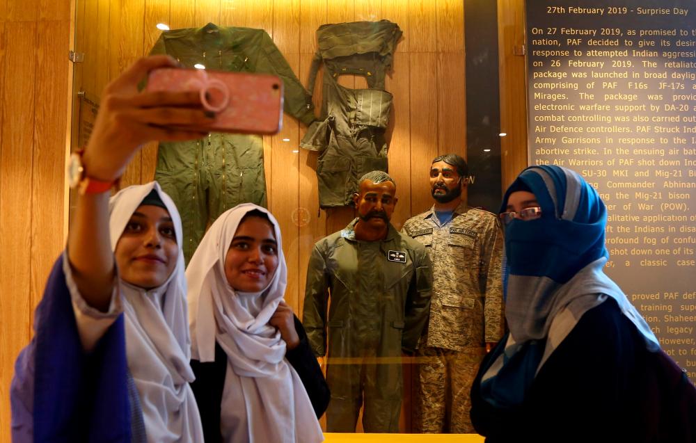 Students take selfies with a mannequin, representing Indian pilot Wing Commander Abhinandan Varthaman, after his Mig-21 fighter aircraft was shot down by Pakistan Air Force on February 27, 2019, at a gallery ‘Operation Swift Retort’ at the Pakistan Air Force (PAF) Museum in Karachi, Pakistan November 13, 2019. - Reuters