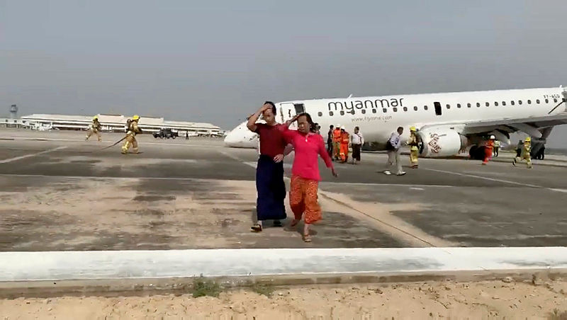 Passengers walk away from the plane after Myanmar National Airlines flight UB103 landed without a front wheel at Mandalay International Airport in Tada-u, Myanmar May 12, 2019 in this still image taken from social media video.