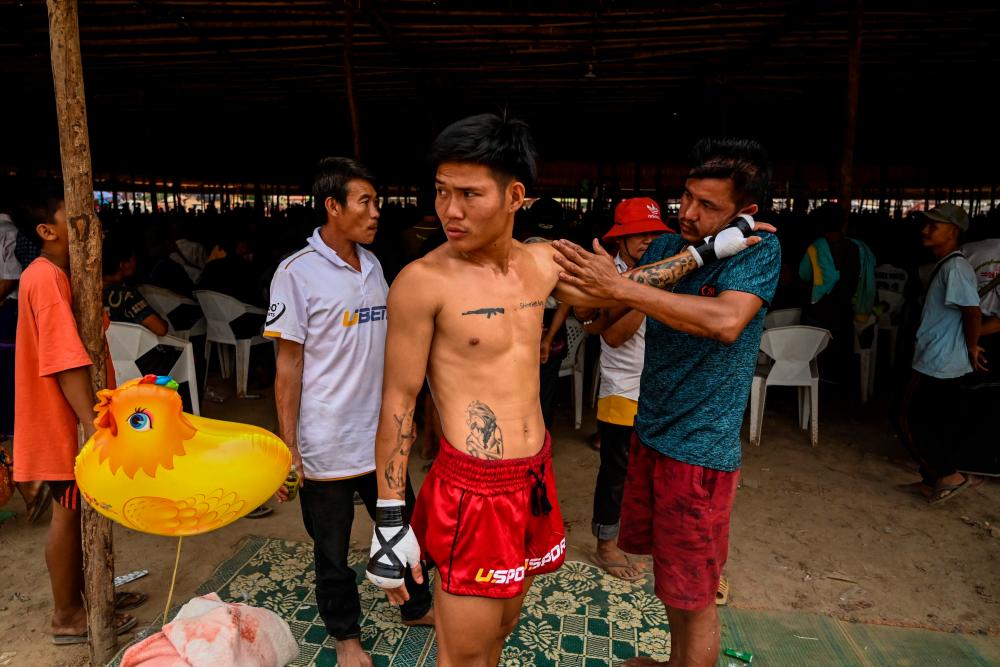 This photo taken on March 5, 2023 shows fighter Hlaing Htet Aung preparing for his bout during a traditional Myanmar boxing Lethwei tournament at Pyi Thar Lin Aye pagoda in Hlaingbwe township in Karen state/AFPPix