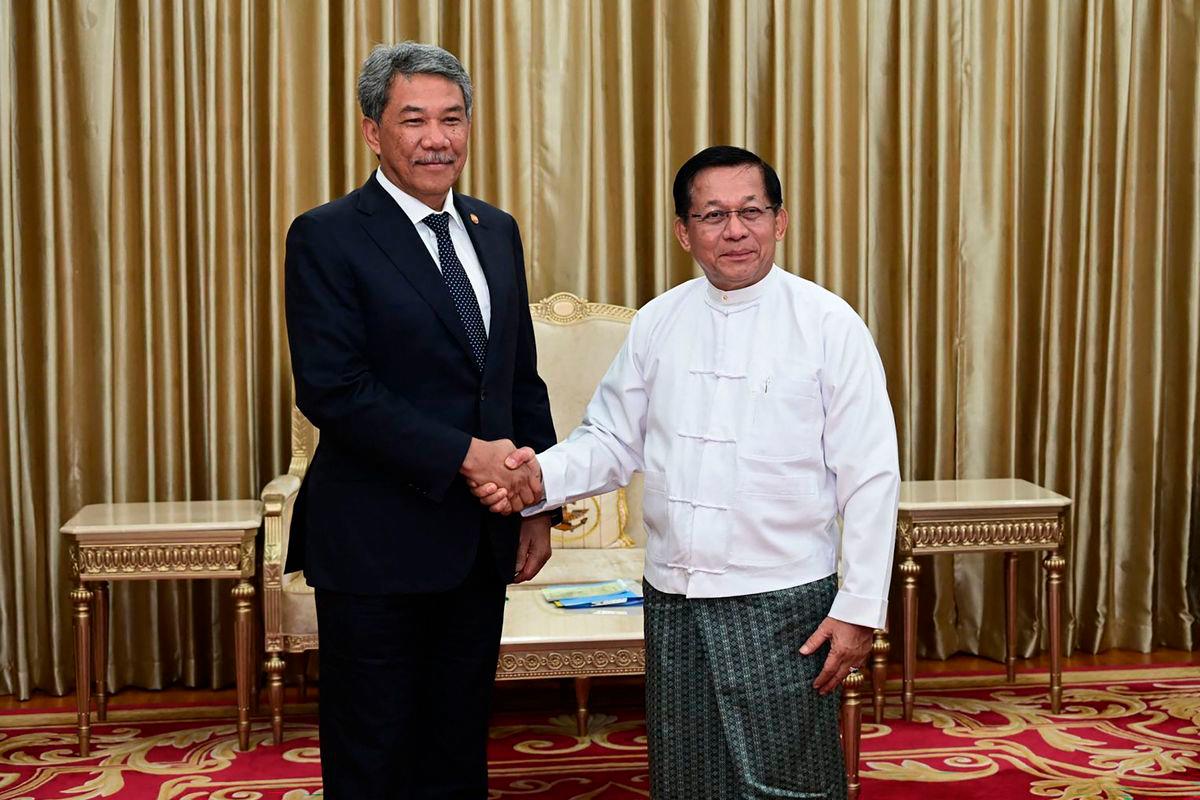 This handout photo taken and released on October 9, 2025 by the Myanmar Military Information Team shows Myanmar’s military chief Min Aung Hlaing (R) shaking hands with Malaysia’s Foreign Minister Mohamad Hasan (L) during a meeting in Naypyidaw. -AFP PHOTO / MYANMAR MILITARY INFORMATION TEAM