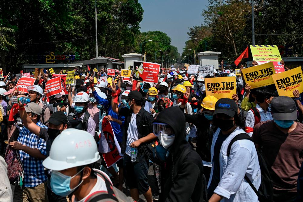 Students come out from Yangon University after the gate was opened as they protest against the military coup in Yangon on February 25, 2021. - AFP