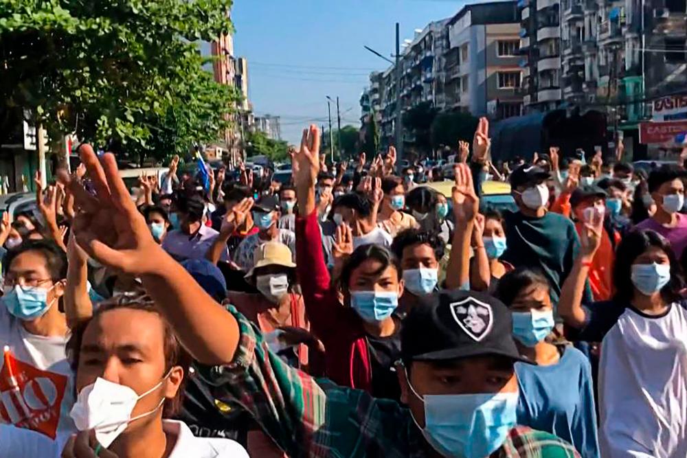 This screengrab from AFPTV video footage taken on May 2, 2021 shows protesters making the three-finger salute as they take part in a flash mob as part of demonstrations against the military coup on Global Myanmar Spring Revolution Day in Yangon. –AFP