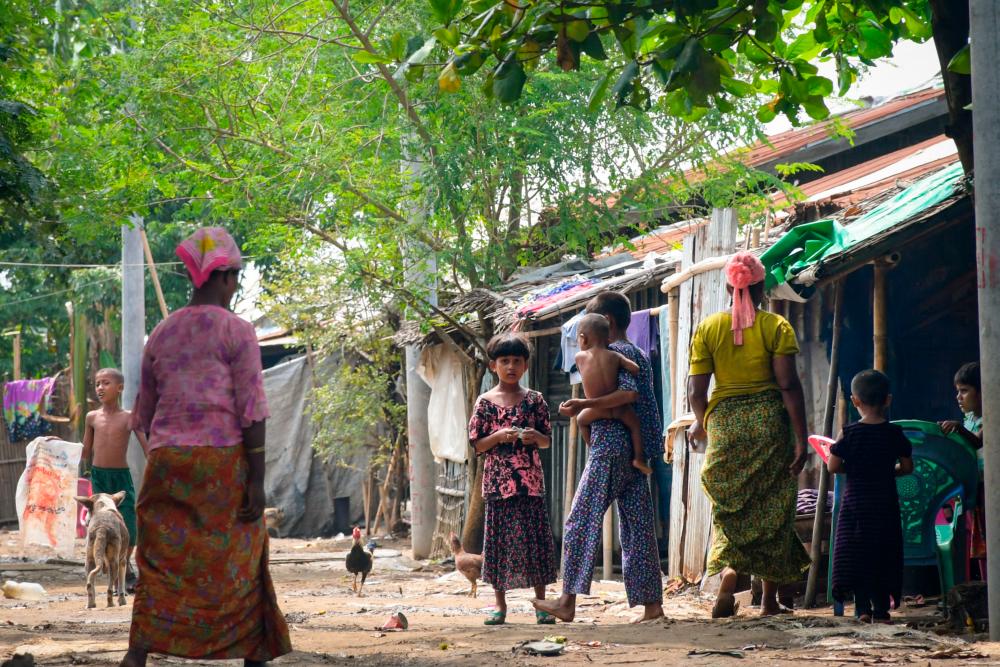 In this photo taken on June 5, 2021, members of the internally displaced Rohingya Muslim community people walk in the Thet Kay Pyin camp in Sittwe, Rakhine state. – AFP