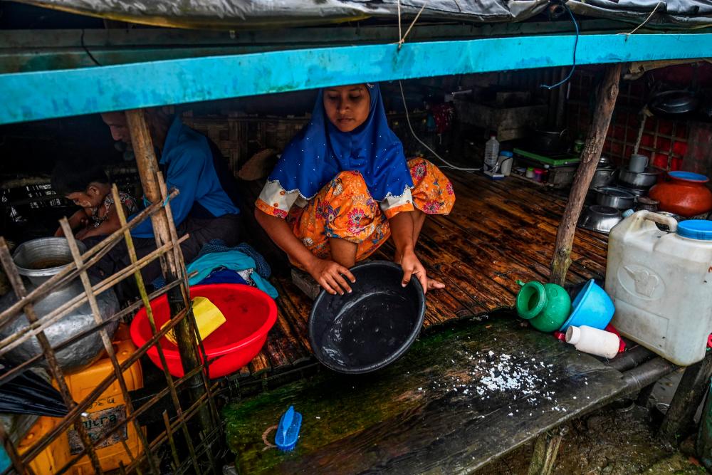 This photo taken on Oct 3, shows a Muslim woman cooking in her tent in Kyauktalone camp in Kyaukphyu, Rakhine state, where Muslim residents have been forced to live for seven years after the inter-communal unrest tore apart the town. — AFP