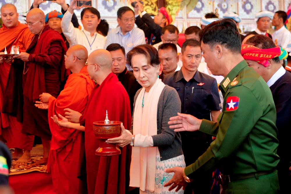 This picture taken on Nov 20, shows Myanmar's State Counselor Aung San Suu Kyi (C) and and Home Affairs Minister Lieutenant General Kyaw Swe (R) attending the opening ceremony of a new pagoda at Kyauktalonegyi city on the outskirts of Taung Gyi, Shan State. — AFP