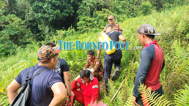 Douglas (sitting on ground, front) with the SAR team members after he was found. -theborneopost.com