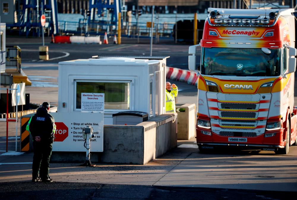 Police officers stand by port security as a lorry drives in at the entrance to the Port of Larne, Northern Ireland, Britain, on Jan 1. Since Britain completed its exit from the EU at the beginning of this year, trade between Northern Ireland and the rest of the United Kingdom has become a flashpoint for ties with the bloc. – REUTERSPIX