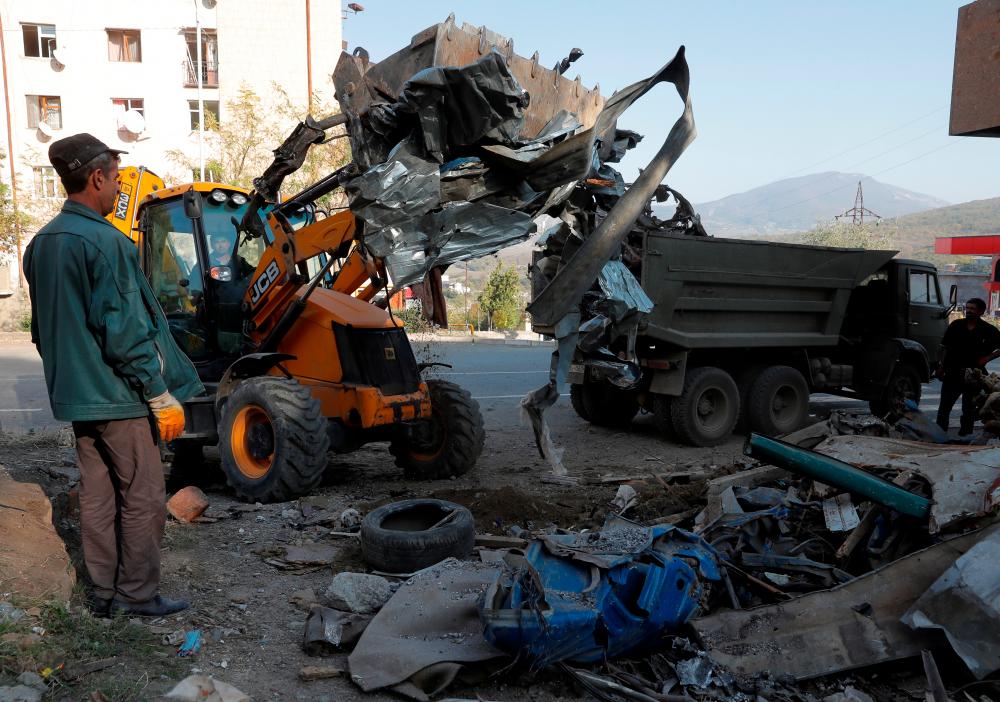 Workers remove debris near a residential building, which was damaged during the military conflict over the breakaway region of Nagorno-Karabakh, in Stepanakert October 19, 2020. — Reuters