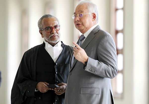 Former prime minister Datuk Seri Najib Abdul Razak has a discussion with this lawyer, Tan Sri Muhammad Shafee Abdullah, outside the courtroom at the Kuala Lumpur High Court on April 22, 2019. — BBXpress