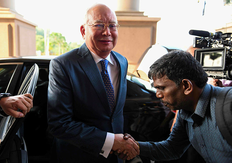 Datuk Seri Najib Abdul Razak shakes hands with a supporter as he arrives at the Kuala Lumpur High Court for his trial, on Aug 19, 2019. — AFP