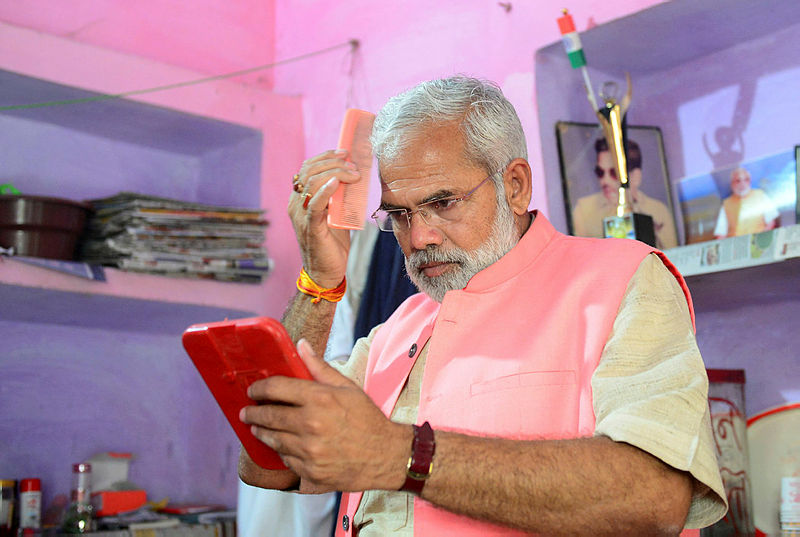 In this photograph taken on April 17, 2019, Abhinandan Pathak, a lookalike of Indian Prime Minister Narendra Modi, combs his hair as he campaigns in a national election bid as an independent candidate in Lucknow in India’s Uttar Pradesh state. — AFP