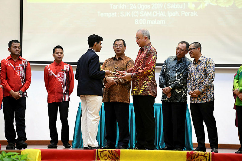 The Sultan of Perak, Sultan Nazrin Shah (3rd R) presents a prize to T. Daksheshkaran, winner of The Royal Oratory Competition (English), at SJKC Sam Chai on Aug 25, 2019. — Bernama