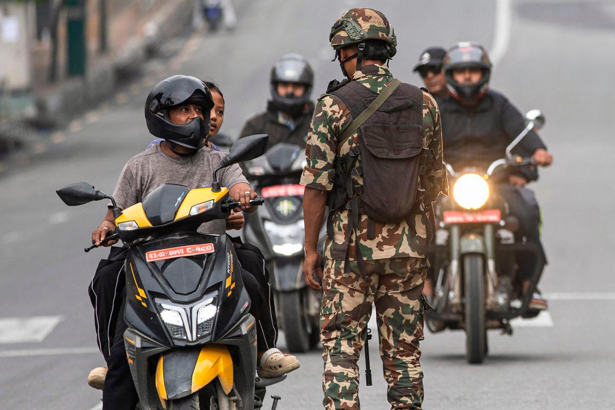 Army personnel inspect identity proof and documents of commuters along a street as part of security measures imposed in Kathmandu on September 10, 2025. (Photo by PRABIN RANABHAT / AFP)