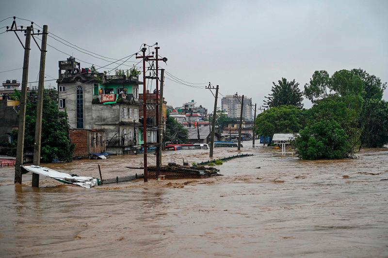 A general view shows houses submerged in flood waters after the Bagmati river overflowed during monsoon rains in Kathmandu on September 28, 2024. Floods and landslides caused by heavy downpours in Nepal killed at least 10 people across the Himalayan country, with rescue teams searching for 18 missing, a disaster official said on September 28. - PRAKASH MATHEMA / AFP