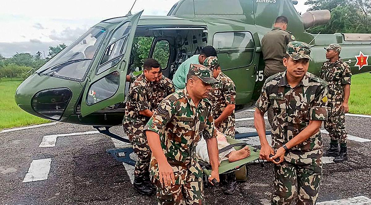 This handout photograph taken and released by Nepal’s Army on October 5, 2025 shows Army personnel carrying a landslide victim evacuated by a helicoper following heavy rain-triggered landslides and floods in Nepal. Landslides and floods triggered by heavy downpours in Nepal have killed at least 42 people, a disaster official said October 5 - AFP PHOTO / Nepal’s Army / - / HANDOUT