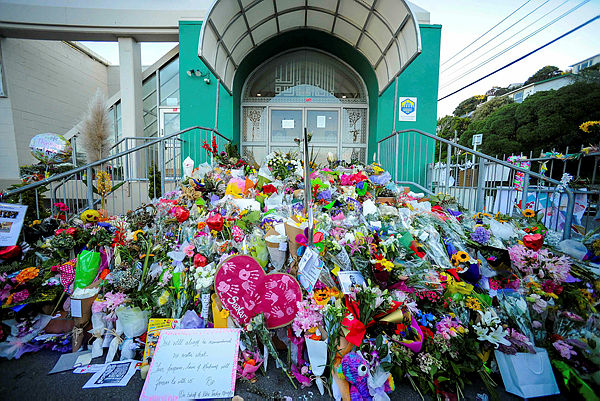 Flowers left by residents are seen at a memorial site for victims of the Christchurch mosque attacks at an Islamic Center in Kilbirnie, Wellington — AFP