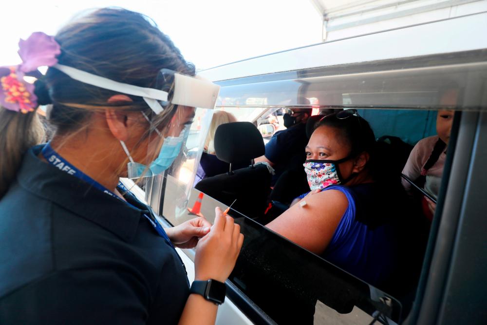 FILE PHOTO: A member of the public receives a Pfizer vaccine at a drive-through coronavirus disease (Covid-19) vaccination clinic in Otara during a single-day vaccination drive, aimed at significantly increasing the percentage of vaccinated people in the country, in Auckland, New Zealand, October 16, 2021. REUTERSpix