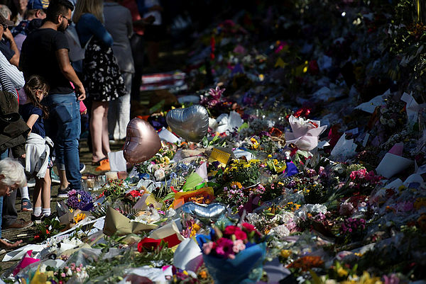Floral tributes to those who were gunned down at the two mosques are seen against a wall bordering the Botanical Garden in Christchurch — AFP
