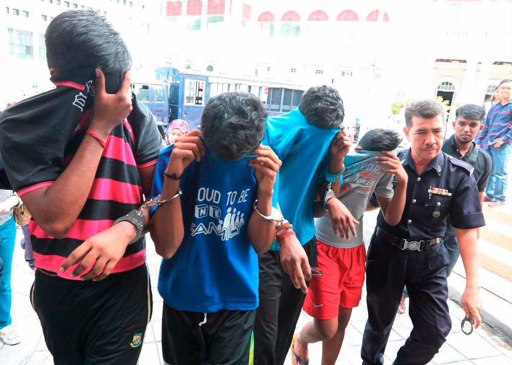 File photo: June 2017 -- J. Ragesuthan,18, V. Sharmah,18, S.Gokulan,18 and another suspect ( K. Tatisan,17 still under age) being led out by police after the were charged with murder and causing grievious hurt at George Town Court Complex. Masry Che Ani/theSun.
