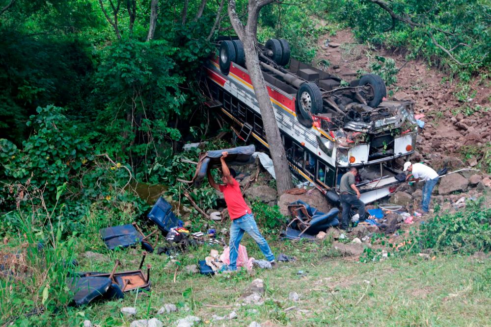 People remove seats from a crashed bus at the Pan-American highway in Condega, Nicaragua, on July 28, 2022. AFPPIX
