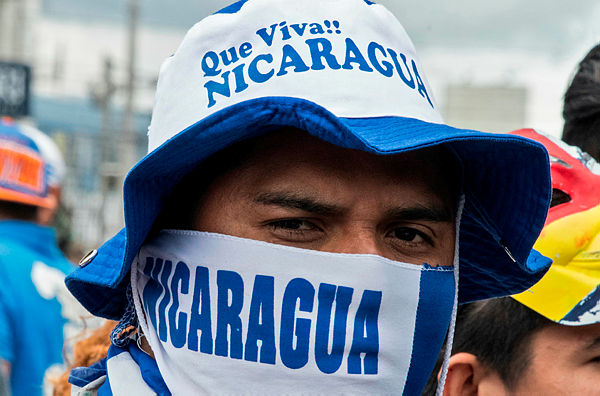A Nicaraguan living in Costa Rica takes part in a protest outside the Nicaraguan Embassy in San Jose against Nicaraguan President Daniel Ortega — AFP