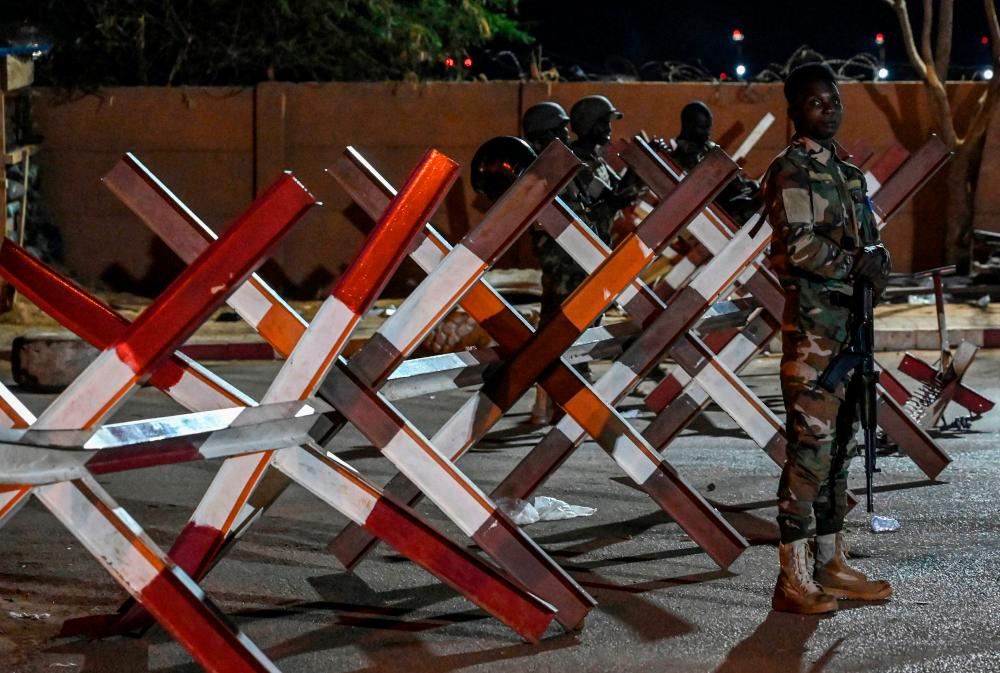 A serviceman stands guard as supporters of Niger's National Council for Safeguard of the Homeland protest outside the French and Niger airbase in Niamey on September 9, 2023 to demand the departure of the French army from Niger. AFPPIX