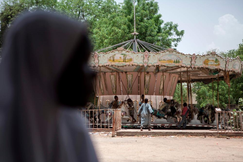 FILE PIX: Children orphaned by Boko Haram Islamists play on a merry-go-round in an abandoned amusement park in Maiduguri, Nigeria, on April 27, 2017. AFPPIX