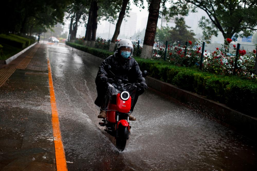 A man riding a Niu electric scooter in Beijing, China. – REUTERSPIX