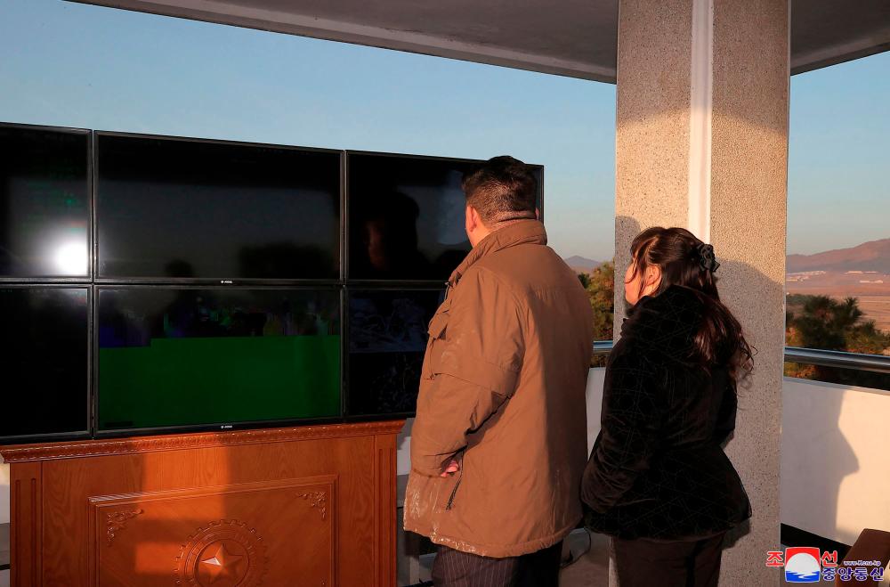 This picture taken on March 16, 2023 and released by North Korea's official Korean Central News Agency (KCNA) on March 17 shows North Korean leader Kim Jong Un (L) witnessing the launch of a Hwasong-17 intercontinental ballistic missile (ICBM) from Pyongyang International Airport. AFPPIX