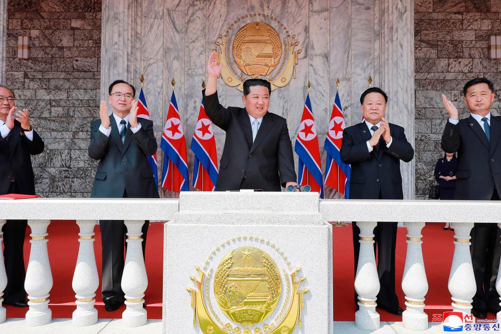 This picture taken on April 15, 2021 and released from North Korea's official Korean Central News Agency (KCNA) on April 16 shows North Korean leader Kim Jong Un (C) waving to the crowd at Kim Il Sung Square to mark the Day of the Sun, the 110th birth anniversary of late North Korean leader Kim Il Sung, in Pyongyang/AFPPix