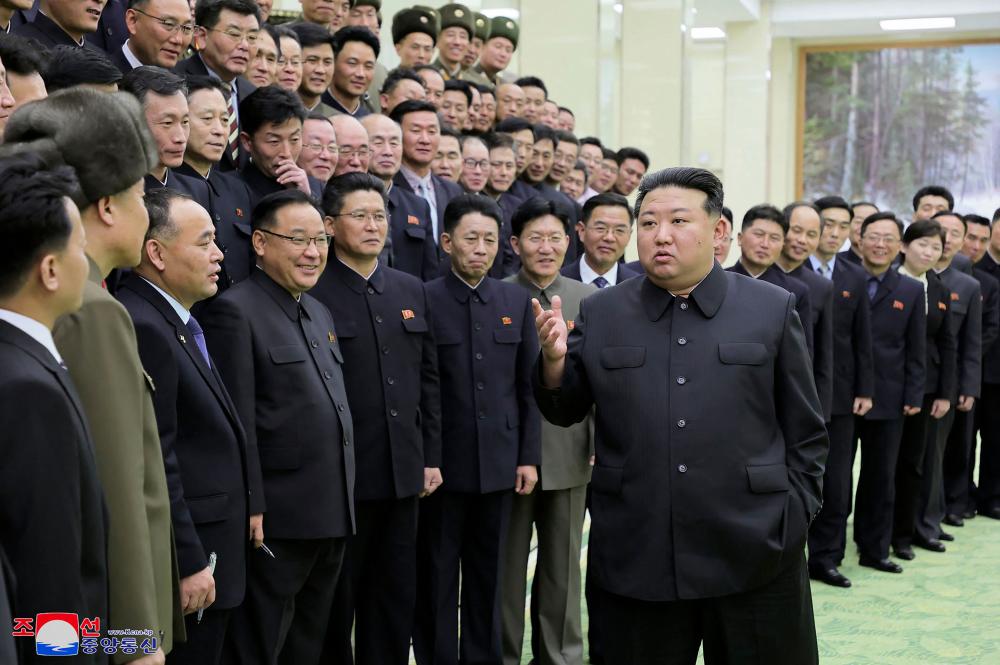 This picture taken on November 23, 2023 and released from North Korea's official Korean Central News Agency (KCNA) on November 24, 2023 shows North Korea's leader Kim Jong Un (front R) meeting with members of the Emergency Satellite Launch Preparation Committee to commemorate the launch of a reconnaissance satellite, at the Mulan Pavilion in Pyongyang. - AFPPIX