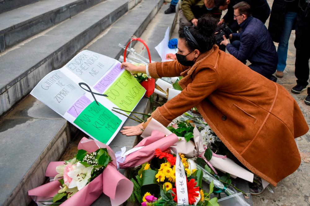 A woman lays flowers as students pay tribute to the students from their elementary school who died after a tourist bus carrying citizens of North Macedonia caught fire and crashed in Bulgaria, in Skopje on November 24, 2021/AFPPix