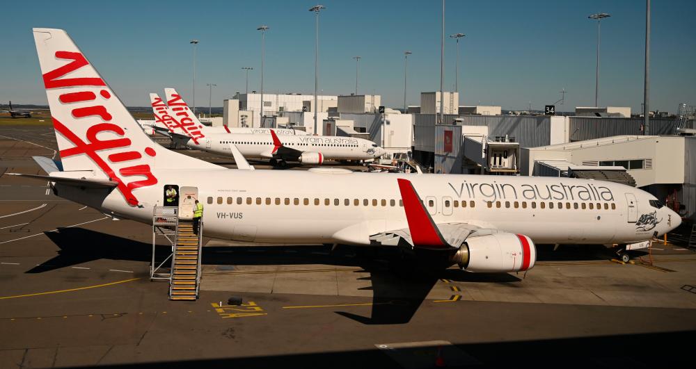 Virgin Australia planes are seen at Sydney airport today. The pandemic-struck carrier is attempting to revive its fortunes following its decision to go into voluntary administration in April. – AFPPIX