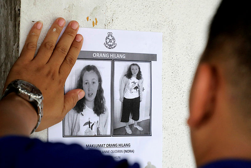 A police officer sticks a photo of 15-year-old Irish girl Nora Anne Quoirin on a wall at a shop in Seremban, Malaysia, Aug 9, 2019. — Reuters