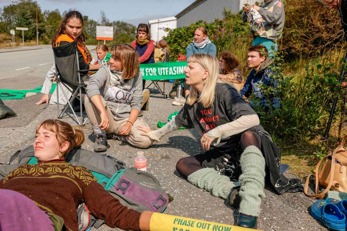 Swedish climate and political activist Greta Thunberg (L) and Norwegian artist and musician Aurora Aksnes (R) together with activists of climate protest group Extinction Rebellion at Equinor’s oil refinery in Mongstad, north of Bergen, Norway, on August 18, 2025. (Photo by Paul S. Amundsen / NTB / AFP)