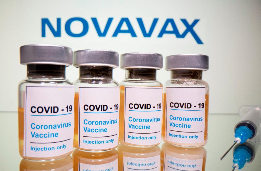Vials of Covid-19 vaccine and a medical syringe are seen in front of a Novavax logo in this illustration. – Reuterspix