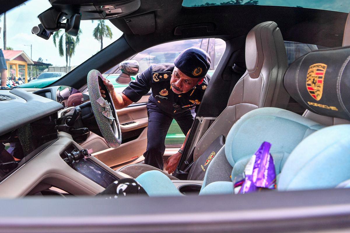 Pengarah Jabatan Pengangkutan Jalan (JPJ) Negeri Sembilan Hanif Yusabra Yusof menunjukkan kereta mewah Porsche Taycan yang disita berikutan tidak diperbaharui Lesen Kenderaan Motor (LKM) oleh pemiliknya pada sidang media di JPJ Cawangan Seremban hari ini. - fotoBERNAMA