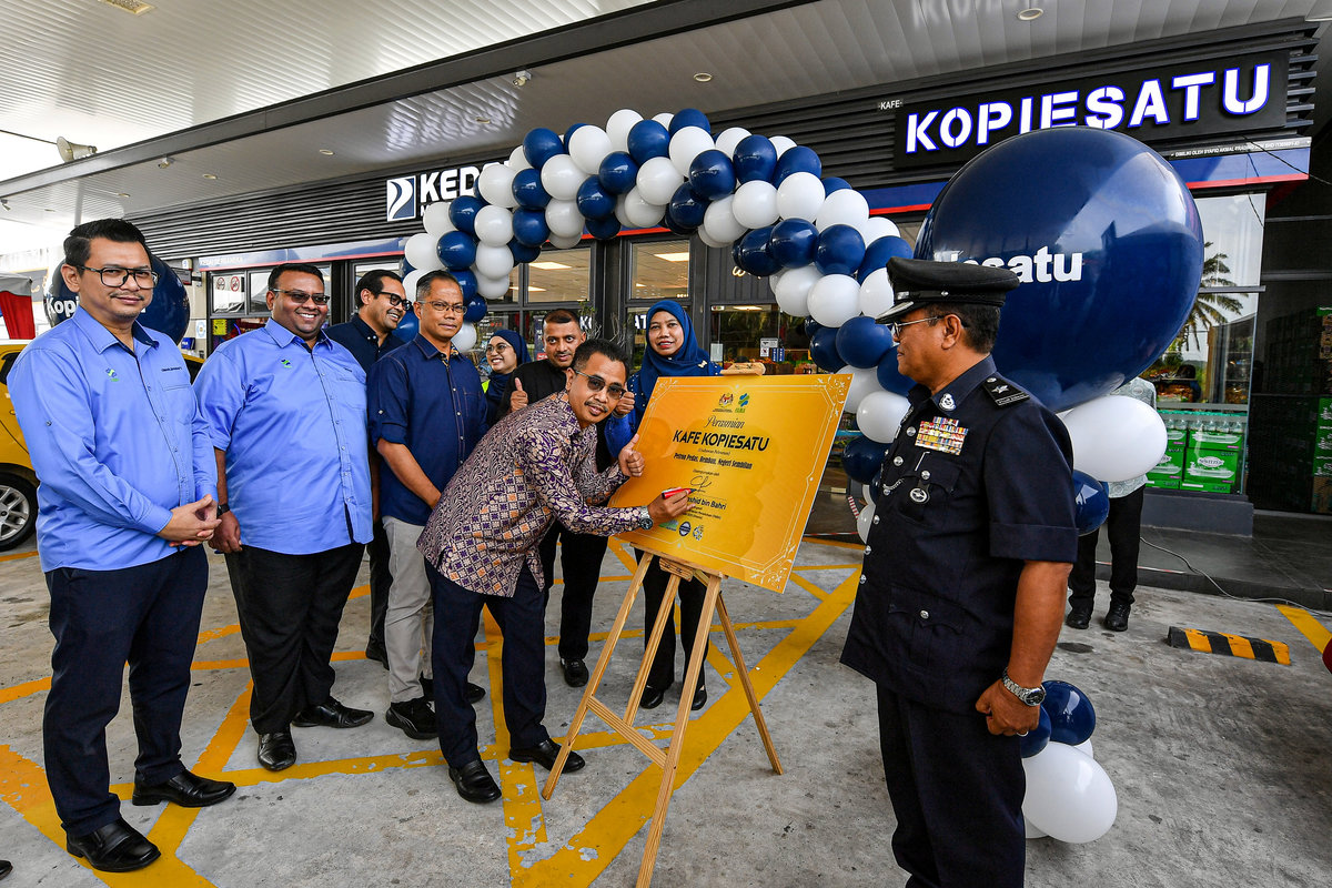 FAMA Director-General Abdul Rashid Bahri (second from right) signing a plaque to symbolise the official launch of the Kopiesatu Outlet at Petron Pedas, today. – BERNAMA