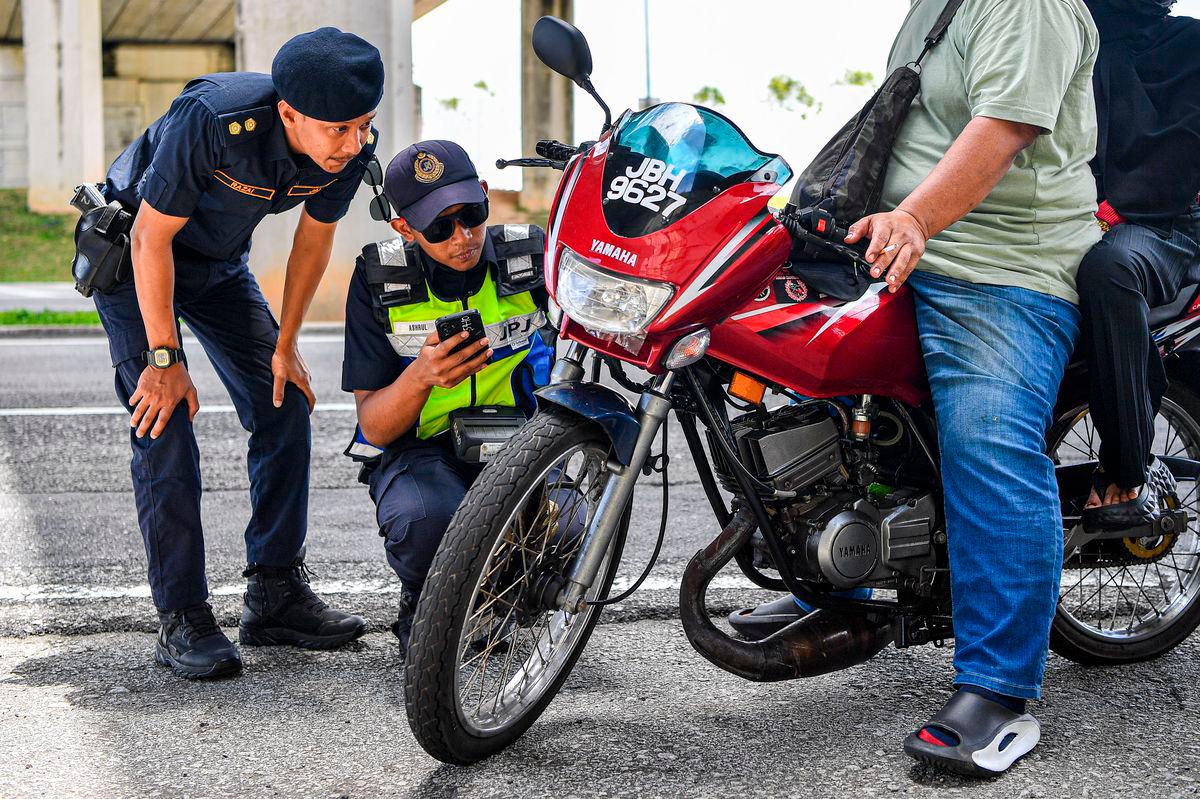 FILE: Anggota JPJ memeriksa motosikal. fotoBERNAMA.