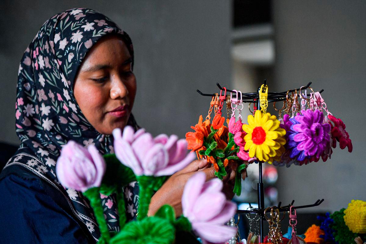 Siti Amirah Pilus melakukan sentuhan akhir pada bunga hiasan yang dibentuk dari dawai baldu di kediamannya, baru-baru ini -BERNAMA