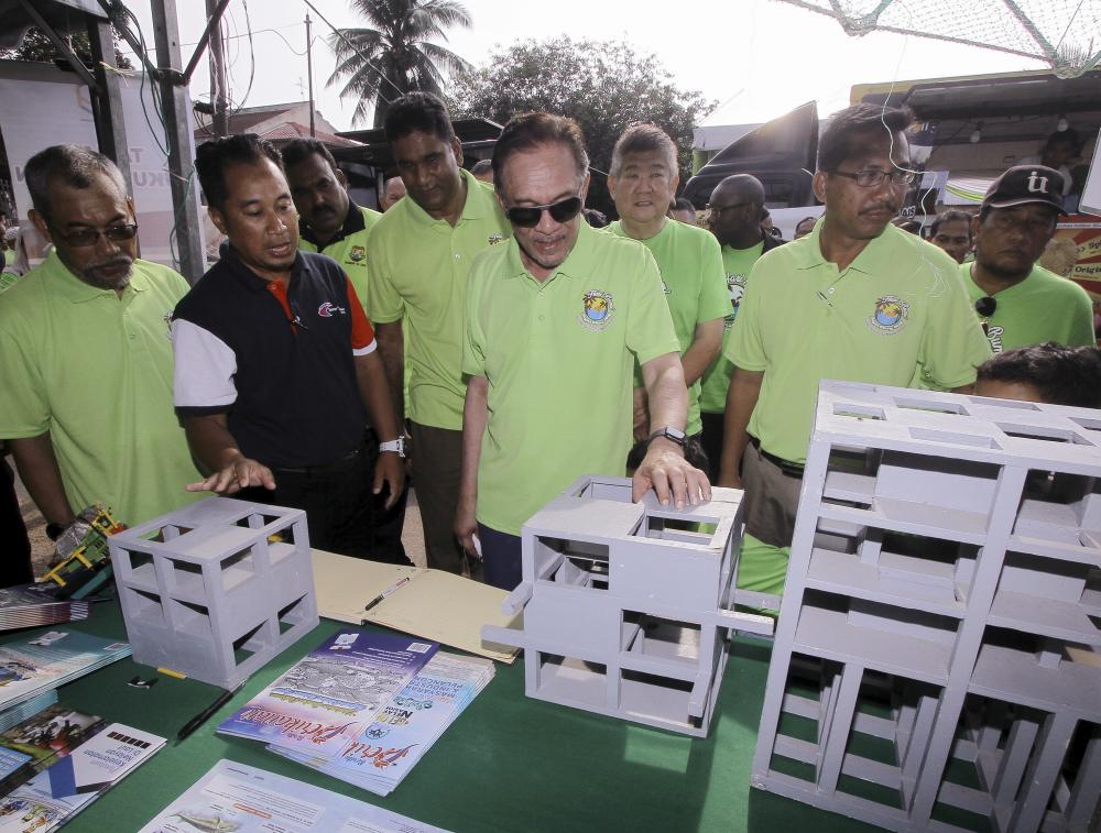 Port Dickson Member of Parliament Datuk Seri Anwar Ibrahim listens to the information from the State Fisheries Director Halimi Abu Hanip (2L) about the reefs exhibited during the exhibition hall at Bagan Pinang state-level Earth Day Program, on April 21, 2019. — Bernama