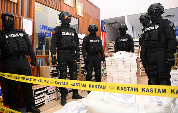 Armed personnel from the Royal Malaysian Customs Department guarding the ketamine and cocaine drugs worth RM676 million that were seized on Aug 18, at a press conference in the Royal Malaysian Customs Department Narcotics Divison in Jijan today.