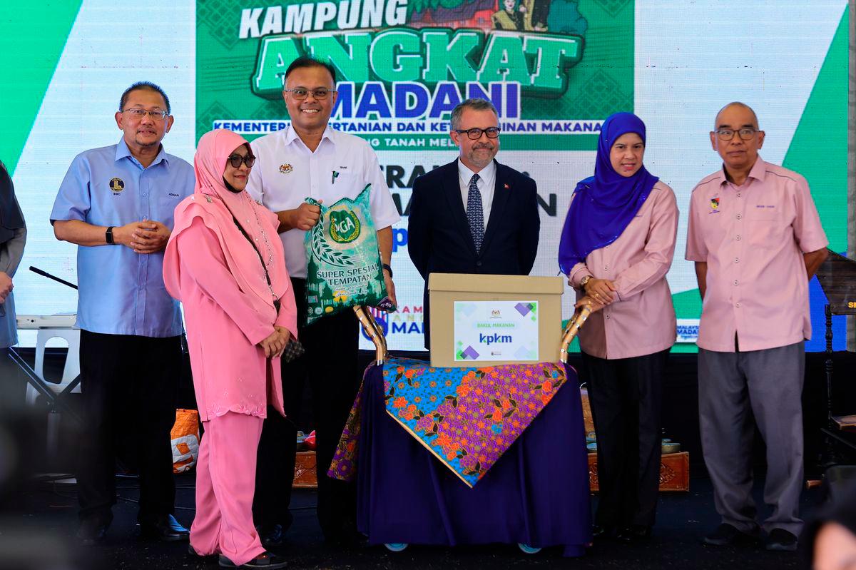 Ketua Setiausaha Kementerian Pertanian dan Keterjaminan Makanan (KPKM) Datuk Seri Isham Ishak menyampaikan sumbangan Bakul Makanan ketika Majlis Peluncuran Kampung Angkat MADANI KPKM di Sekolah Kebangsaan Tanah Melintang hari ini. - BERNAMA
