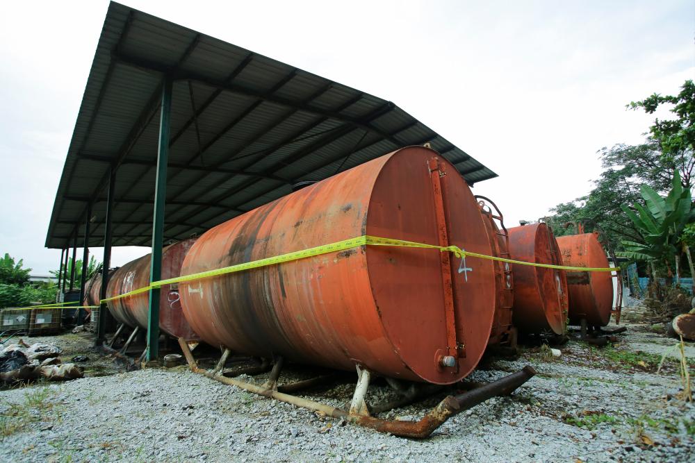 Some of the oil storage tanks illegally stored in Kampung Bemban Hilir today. - Bernama
