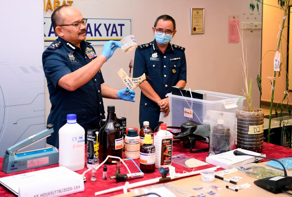 JKDM deputy director-general (Enforcement and Compliance) Datuk Abdul Latif Abdul Kadir (L) displays the materials and equipment used to process drugs that were confiscated at a house in Hulu Kelang, at a press conference today. - Bernama