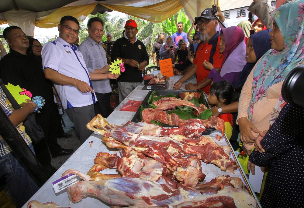 Domestic Trade and Consumer Affairs Minister Datuk Seri Saifuddin Nasution Ismail (2nd from L) with Port Dickson MP Datuk Seri Anwar Ibrahim (3rd from L) visit a meat booth at the Buy Malaysian Goods-Consumer Sales Carnival, Port Dickson on May 4, 2019. - Bernama