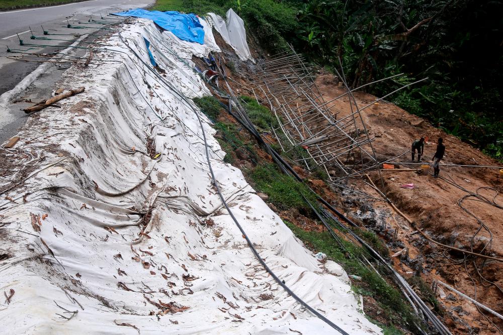 SEREMBAN, Feb 2 -- Two workers are installing construction scaffolding on a slope of land that has collapsed causing cracks in the road on Jalan Persiaran Senawang 3 (N035), today. BERNAMAPIX