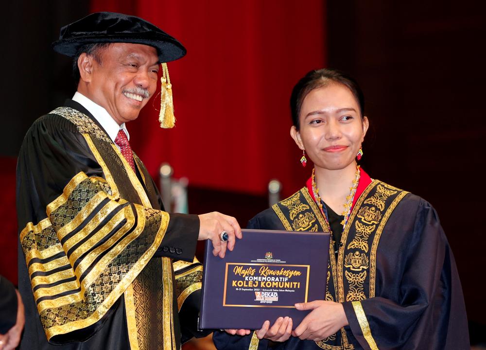 Timbalan Menteri Pendidikan Tinggi Datuk Mohammad Yusof Apdal (kiri) menyampaikan sijil Teknologi Maklumat kepada Aneasthacia Esira Anak Mike Susan dari Sarawak pada Majlis Konvokesyen Kolej Komuniti di Universiti Sains Islam Malaysia (USIM) pada Sept 19 2023. - fotoBERNAMA