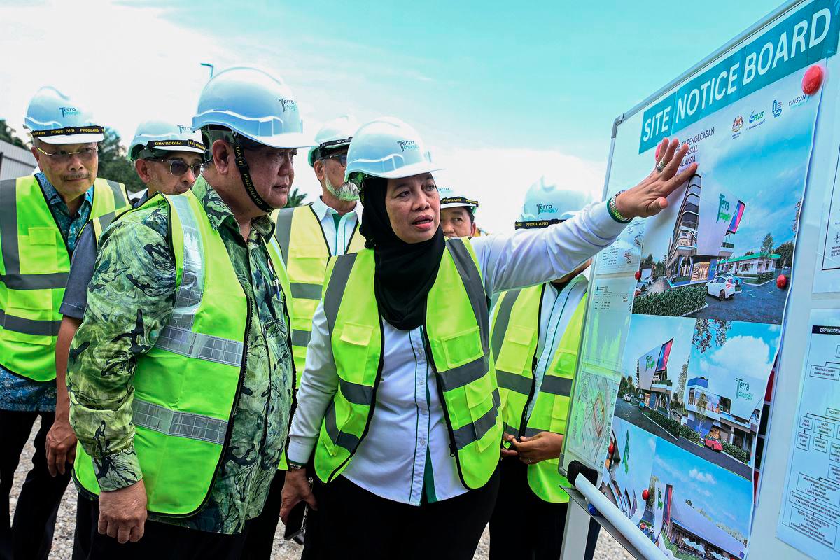 Works Minister Datuk Seri Alexander Nanta Linggi (left) listens to an explanation on the design of the Integrated EV Charging Hub by PLUS Malaysia Managing Director, Datuk Airina Nik Jaafar (centre), during the Groundbreaking Ceremony for Malaysia’s First Integrated EV Charging Hub at the Seremban R&amp;R (Southbound), today. – BERNAMA