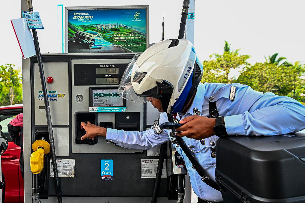 Anggota Penguatkuasaan Trafik IPD Seremban Mohammad Khidir Mohammad Shamsuri membuat bayaran menggunakan papan kekunci yang telah tersedia bagi menggunakan petrol RON95 di stesen Petronas S2 City Park pada harga RM1.99 seliter, berbanding harga pasaran RM2.05 seliter, menerusi inisiatif BUDI MADANI RON95 (BUDI95) yang bermula hari ini. - fotoBERNAMA